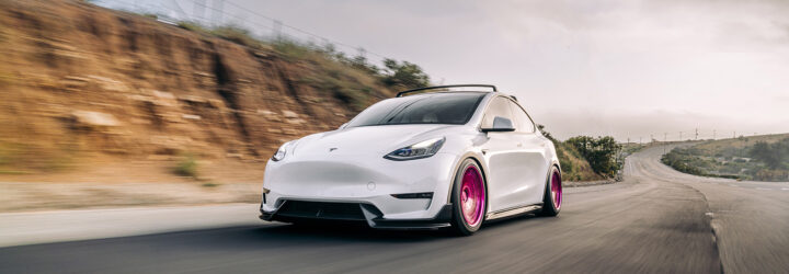 A white car zooming down a highway