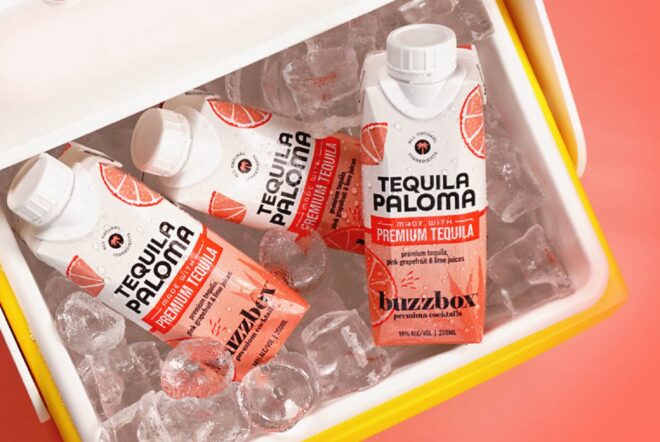Orange-pink drinks in a yellow cooler against an orange background