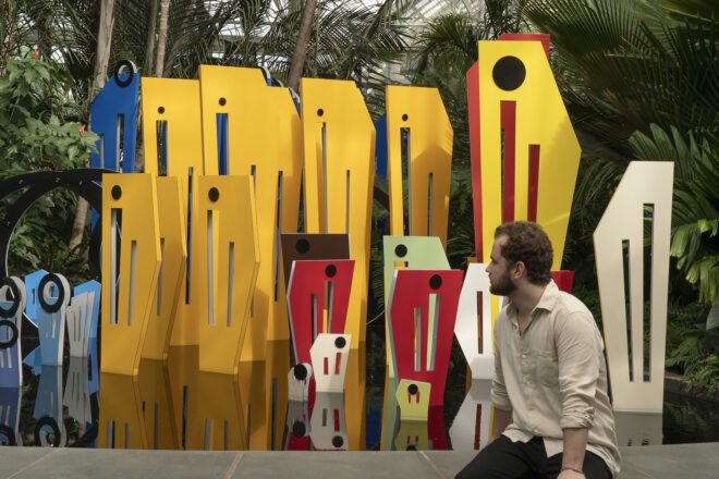 A man sitting beside a pool containing an art installation