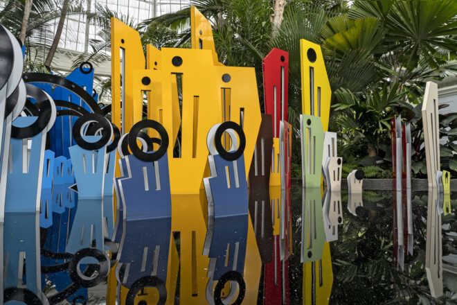 An art installation with blue cutouts in front of yellow and red taller cutouts