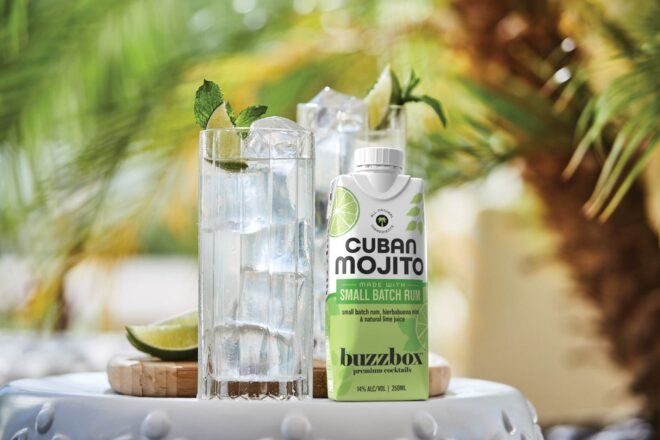 Two cups of clear alcohol with slivers of lime