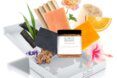 A white box with ingredients floating out of it including bars of soap