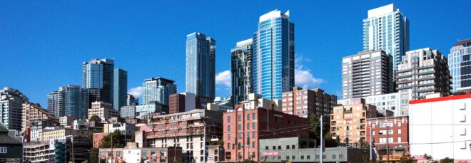 A city skyline filled with skyscrapers in the background and smaller high-rises in the foreground