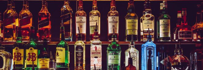 Two shelves lined with liquor and alcohol