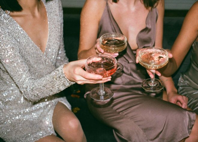 Three women clinking glasses filled with some kind of liquid