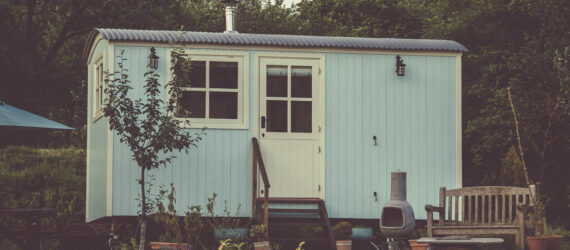 A cute tiny home with a small porch and stairs