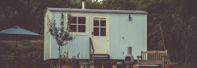 A cute tiny home with a small porch and stairs