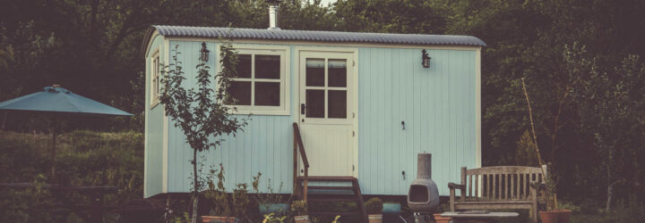 A cute tiny home with a small porch and stairs