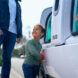 A child close to the vehicle smiling