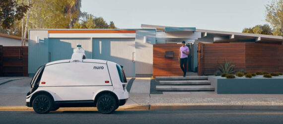 Nuro parked outside a house as someone walks toward it