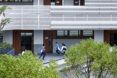 A gray building with students on the first ground floor