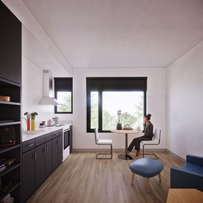 Another angle of the bedroom with a sitting area near a large window