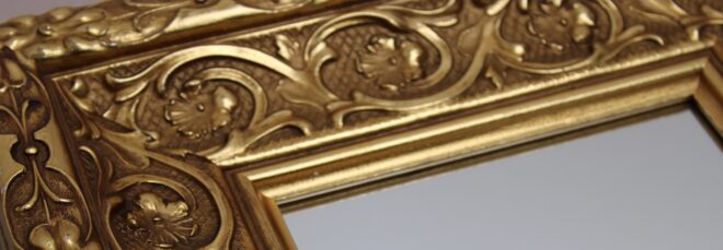 A mirror with a bronze frame
