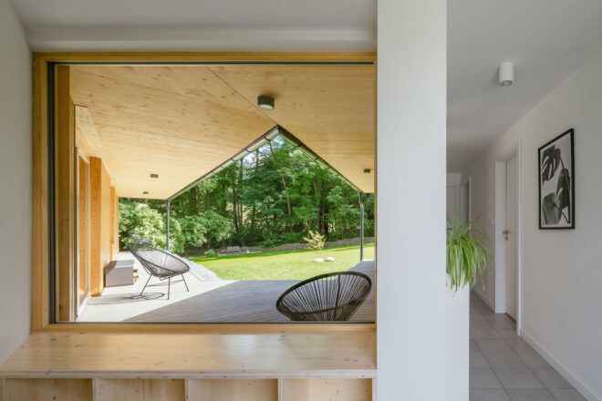 Through the window on the inside with natural wood and a sitting area