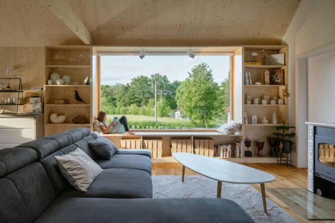 Living room with natural wood bookshelves and a large window