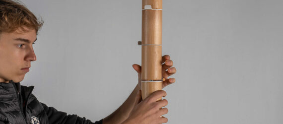 A man holding a coat rack with both his hands