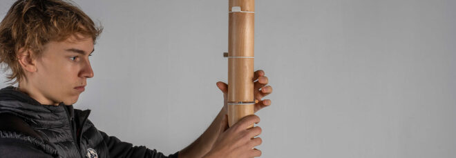A man holding a coat rack with both his hands