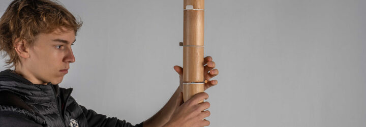 A man holding a coat rack with both his hands