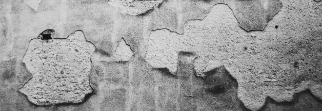 A concrete wall that is chipped in some places