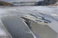 A sandy area with a white structure from it