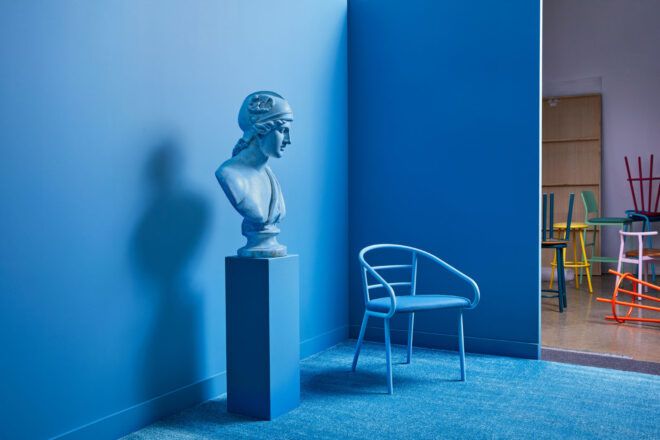 Blue metal chair near a sculpture in a blue room