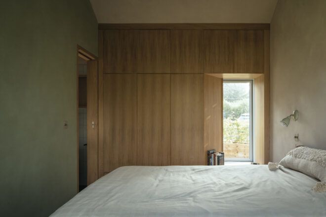 Simple wooden bedroom with large vertical window
