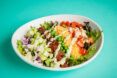 A large salad on a blue backdrop