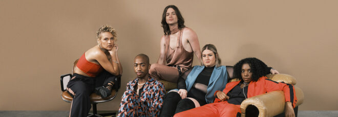 Five people posing and lounging in and around a sofa against a brown backdrop