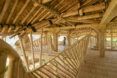 A hallway under a roof all made out of bamboo