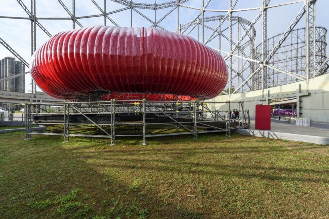 A red inflatable structure by a grass lawn