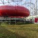A red inflatable structure by a grass lawn