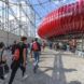 A group of people walking toward an inflatable round red object