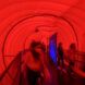 People walking within a red tube passing through a blue divider