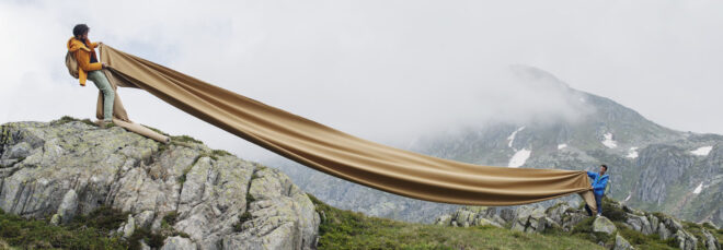 Stretched fabric on a mountain held between two pepole