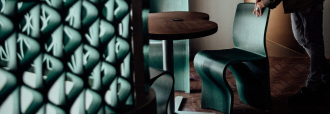 View near the mezzanine railing towards a man holding the top of a green chair