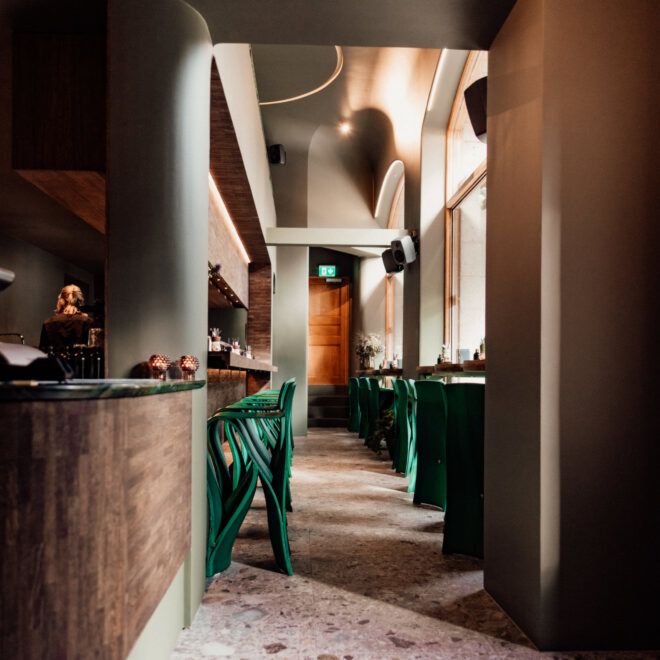 Passage with a bar on the left and seating facing the window on the right