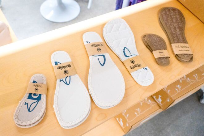 Different shoe insole sizes laid across a wooden shelf
