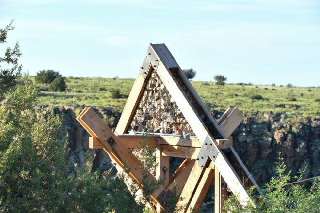 Close up of the top triangular frame of The Octahedron which features a gabion-like mesh filled with rocks