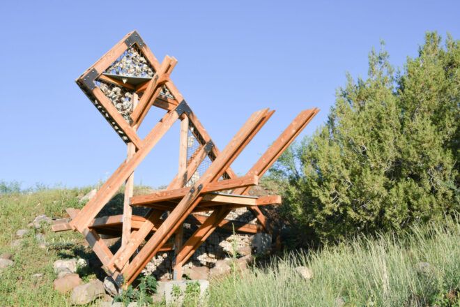 Interlaced timber form that features gabions on a sloped site