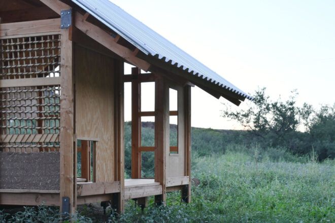Corner view of the Earth Shed featuring the earth-plastered wall and timber frame