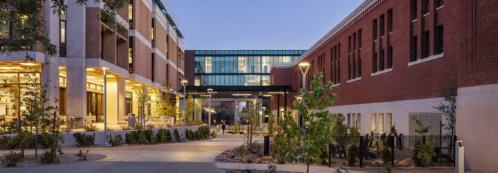 Multiple renovated buildings on the campus at dusk
