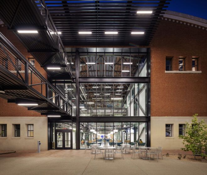 Large glass windows into a brick building and bridge
