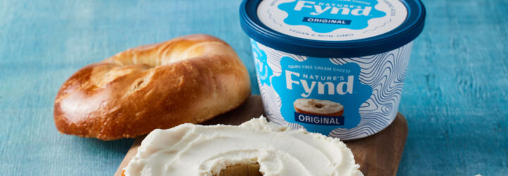 Blue background with dairy-free cream cheese bread on a bagel