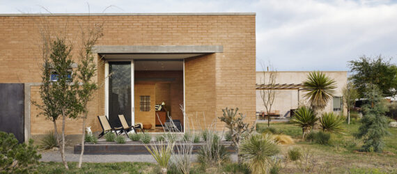 A rectangle low brick building in a desert landscape