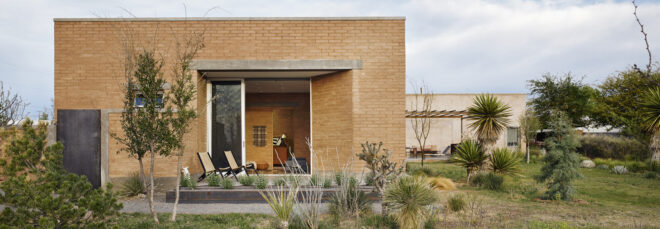 A rectangle low brick building in a desert landscape