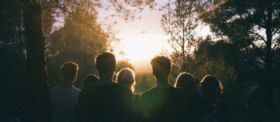 People in the woods looking at the sunrise