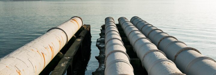Four sewage pipe leading out to a river