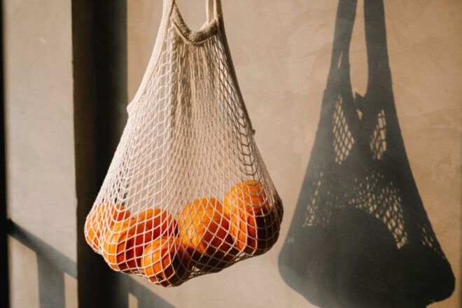 A bag of oranges in a reusable mesh bag