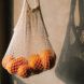 A bag of oranges in a reusable mesh bag