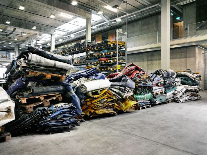 Truck tarps piled up in a warehouse to be used